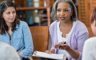 Woman with clipboard talking to small group